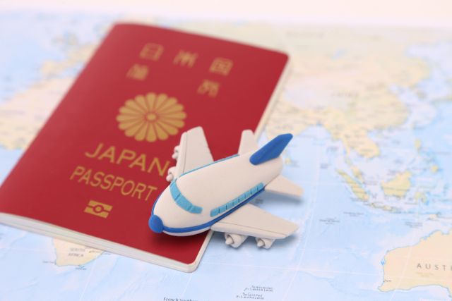 地図の上に置かれたパスポートと粘土の飛行機