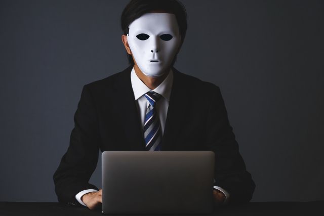 マスクをつけてパソコンの前に座るサラリーマン