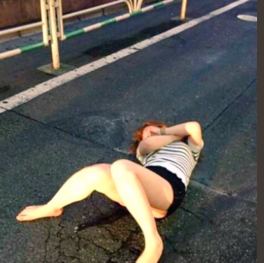 路上で寝ている女性