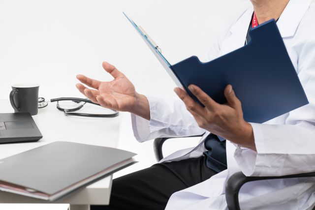 カルテを見ながら問診する医師