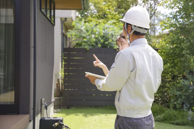 家の前で建築業者と打ち合わせ