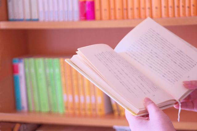 本棚に並ぶ本とそれを読む人