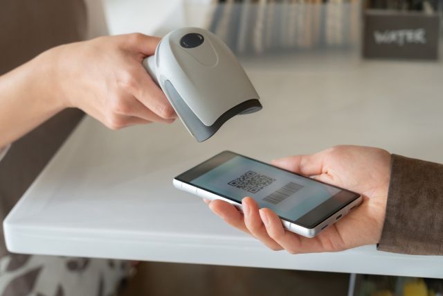 カフェでスマホ決済で支払う人