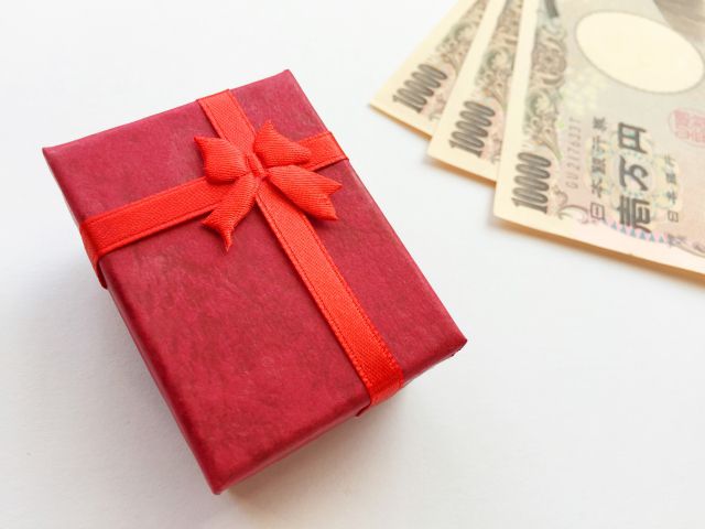 赤い包装紙に包まれたプレゼントと現金
