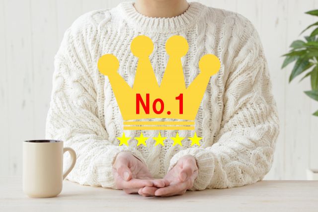 No.1を差し出す白いセーターの男性
