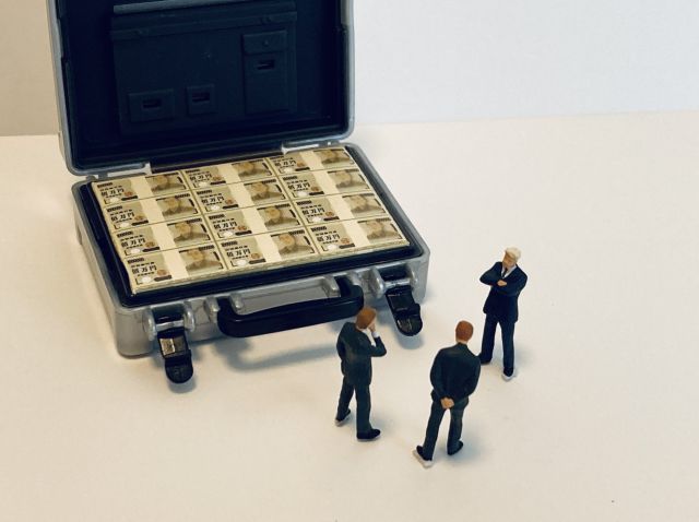 大金が入ったアタッシュケースを見る人形