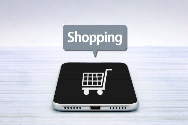 スマホの画面に表示されたカートと吹き出しに書かれたShoppingの文字
