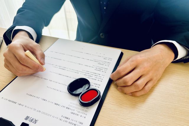 契約書に印鑑を押す男性