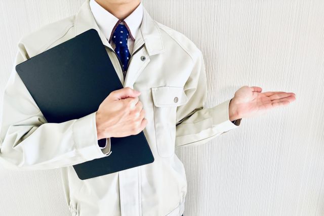 作業服を着て案内する男性スタッフ