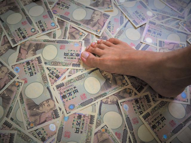 床に散乱した1万円札を踏みつける足