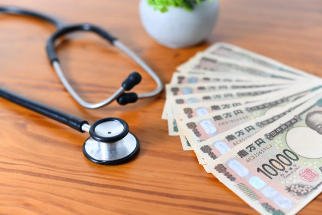 机に置かれた聴診器とお金