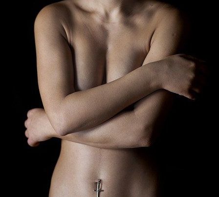 裸で胸を隠した女性モデル