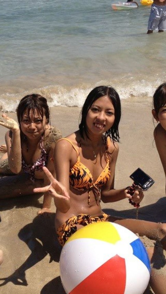 海辺でピースをしているビキニの女性