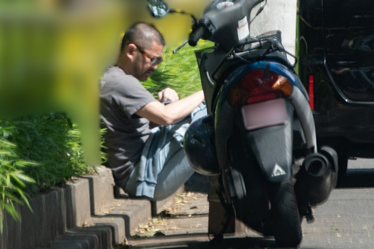 バイクの横に座る男性