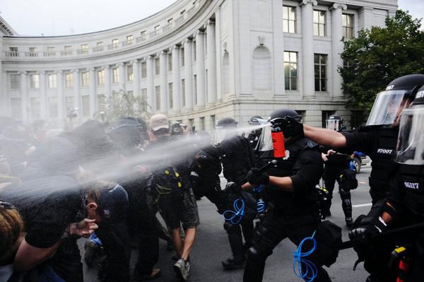 暴徒鎮圧のために催涙剤を吹きかける警察