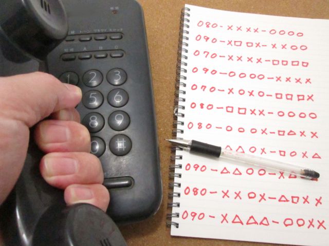 電話機と電話番号が羅列しているノート