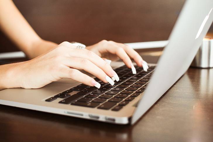 Macパソコンをタイピングする女性