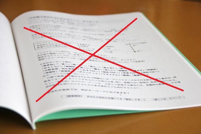 赤ペンでバツが書かれたファイルの入った資料