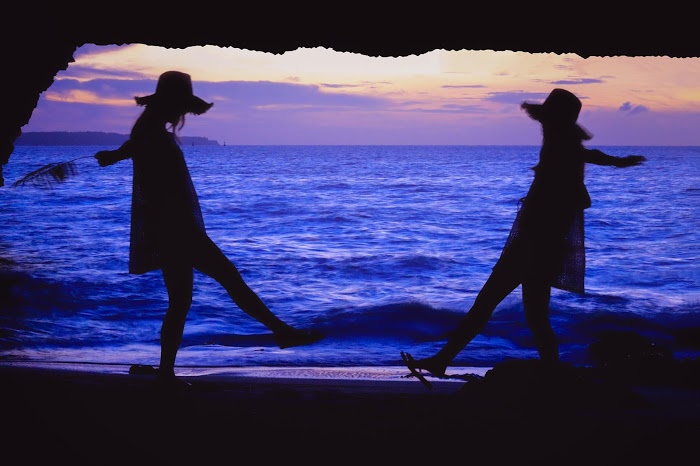 夕焼けの海辺の女性二人