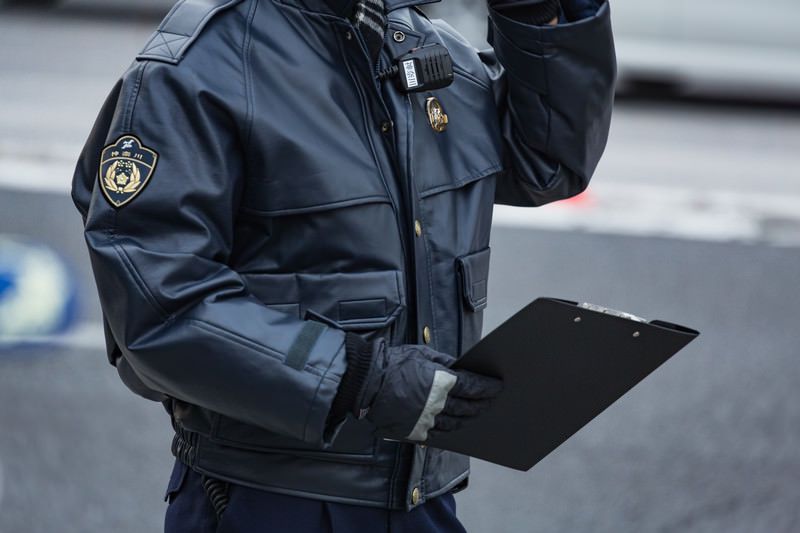 冬用の革ジャンを着て手にファイルを持った警察官