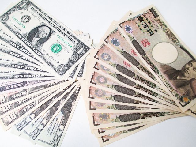 広げたドル札と1万円札