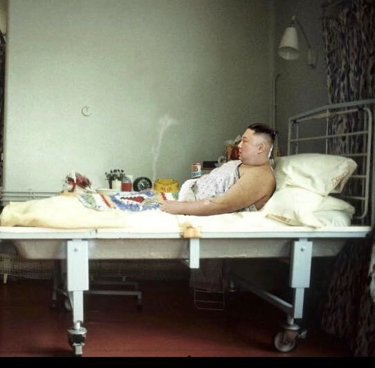 病室のベッドの上で酒とタバコ男性