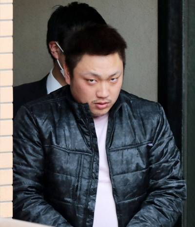 黒い上着を着た目つきの悪い男